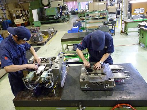 金型組立・調整・トライをする二人の作業員